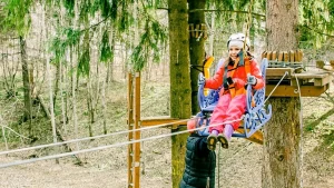 Девочка катается на веревочной дороге в парке «Тишино»