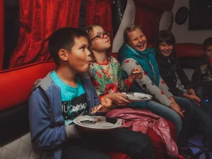 Дети едят пиццу в лимузине на квесте