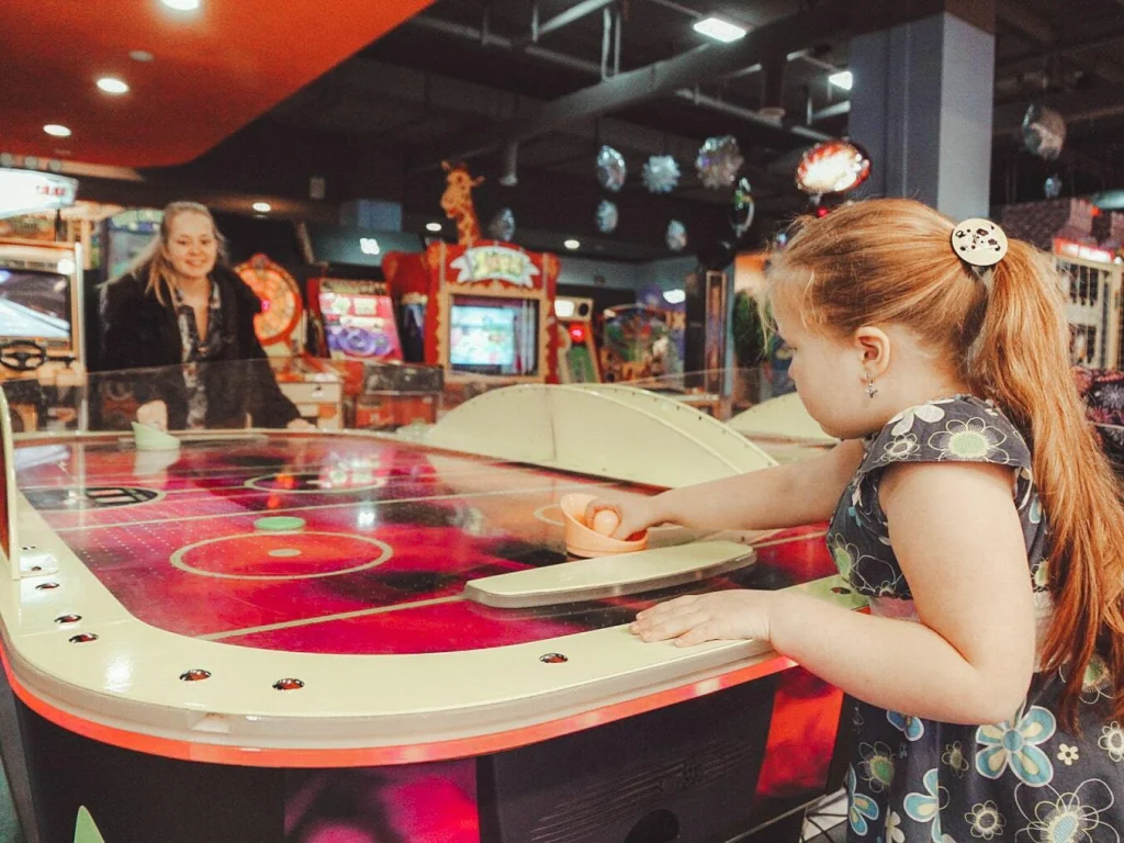 Девочка играет в хоккей с мамой в центре «Игромакс»