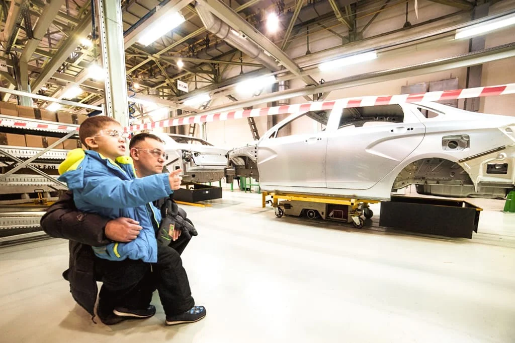 Мальчик с папой смотрят на кузов LADA на экскурсии в Ижевске