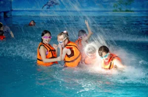 Дети в оранжевых жилетах играют под водой в аквапарке «Ривьера»