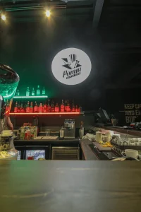 Барная стойка с бутылками и логотипом бургерной «Ронни»
