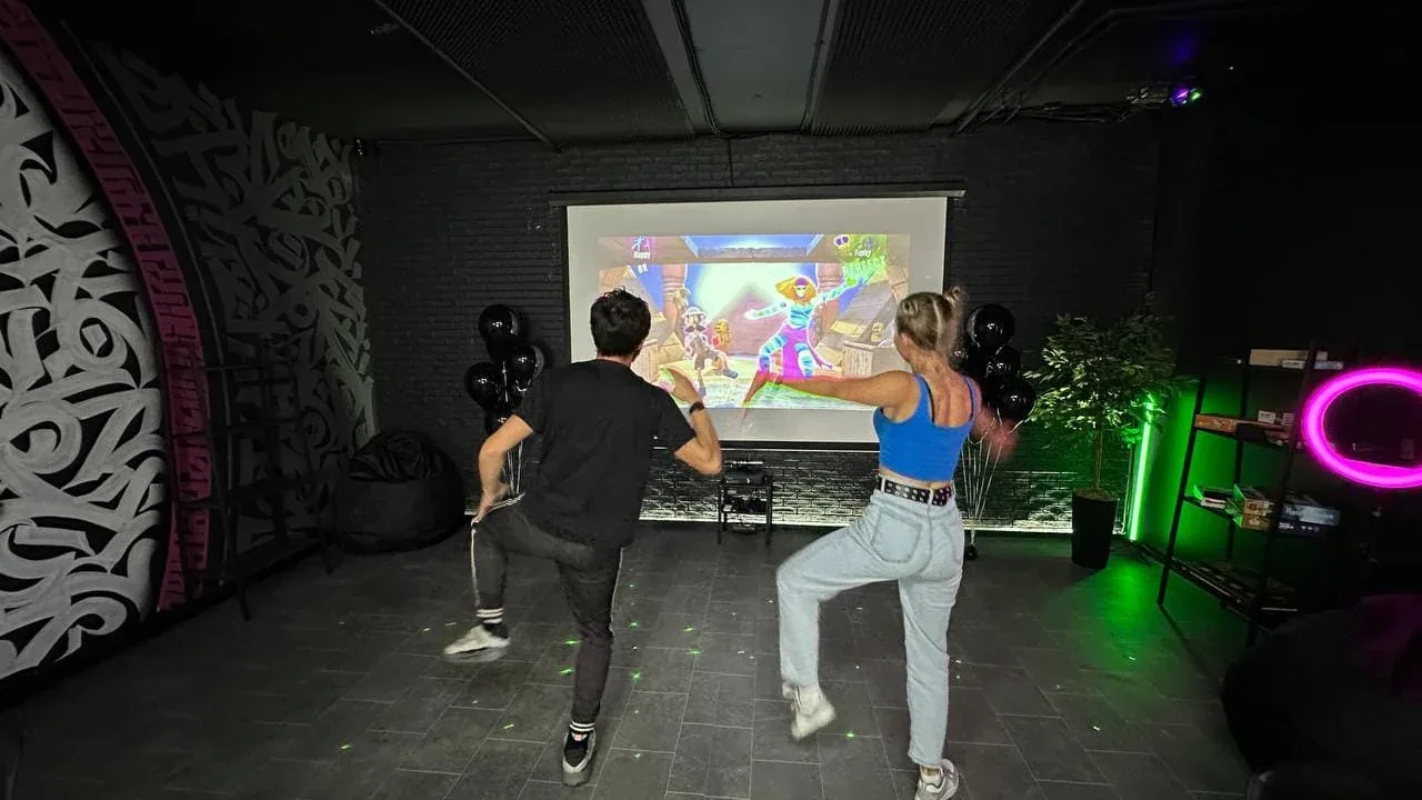 Гости танцуют перед большим экраном с Xbox Kinect