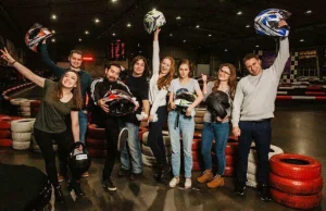 Группа людей с шлемами на картинг-треке в клубе «Форсаж»