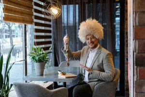 Мужчина в папахе держит шашлык в ресторане «Кинза»