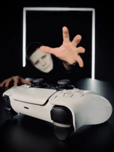 Игрок в маске тянется к геймпаду в VIP-комнате с Sony PlayStation 5