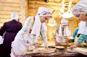 Женщины в народных костюмах готовят тесто в «Туган Авылым»