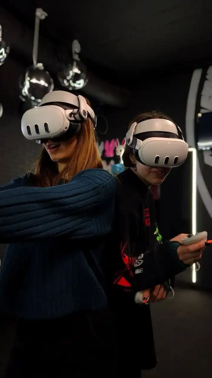 Две гостьи играют в VR-шлемах под дискошарами