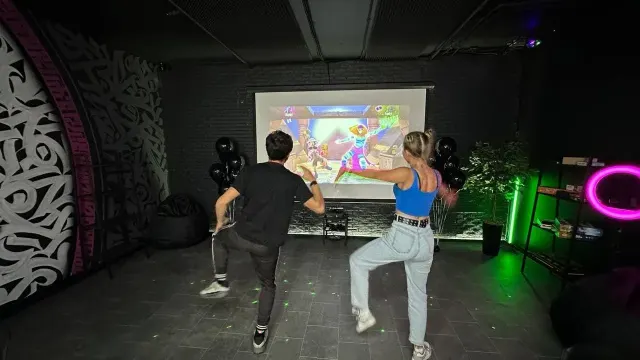 Гости танцуют перед большим экраном с Xbox Kinect в клубе escape.