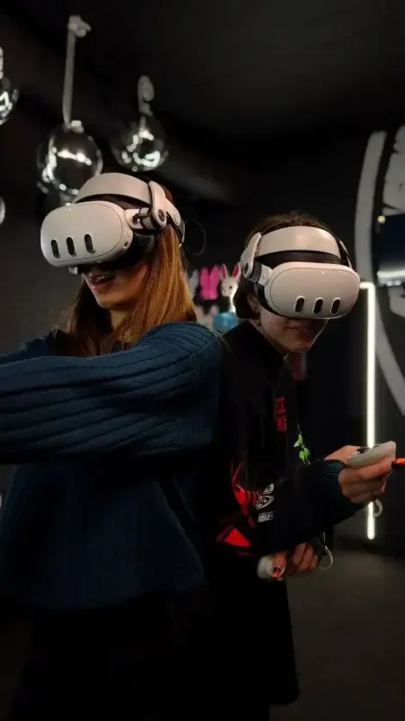 Две гостьи играют в VR-шлемах под дискошарами